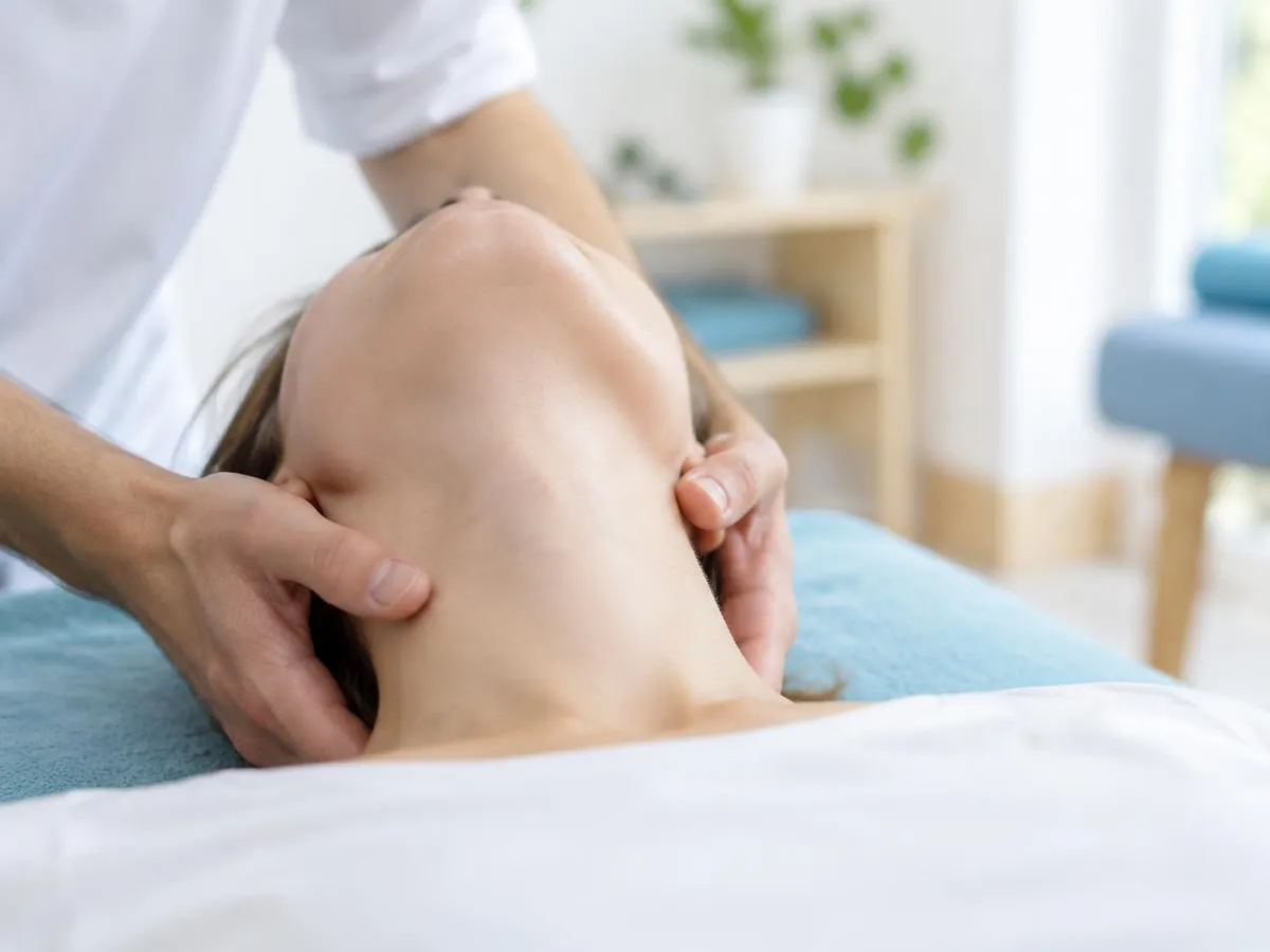 Deux mains soutenant délicatement la nuque d'une personne allongée